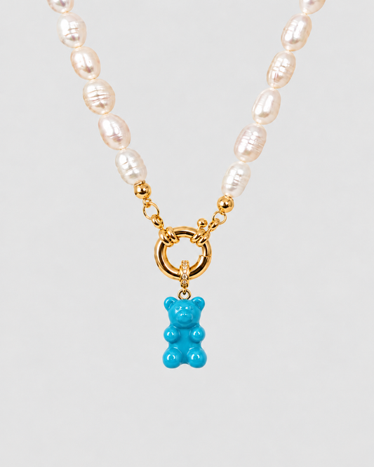 Natural_Pearl_Necklace_with_gold_details_and_turquoise_gummy_bear_pendant_on_light_grey_background