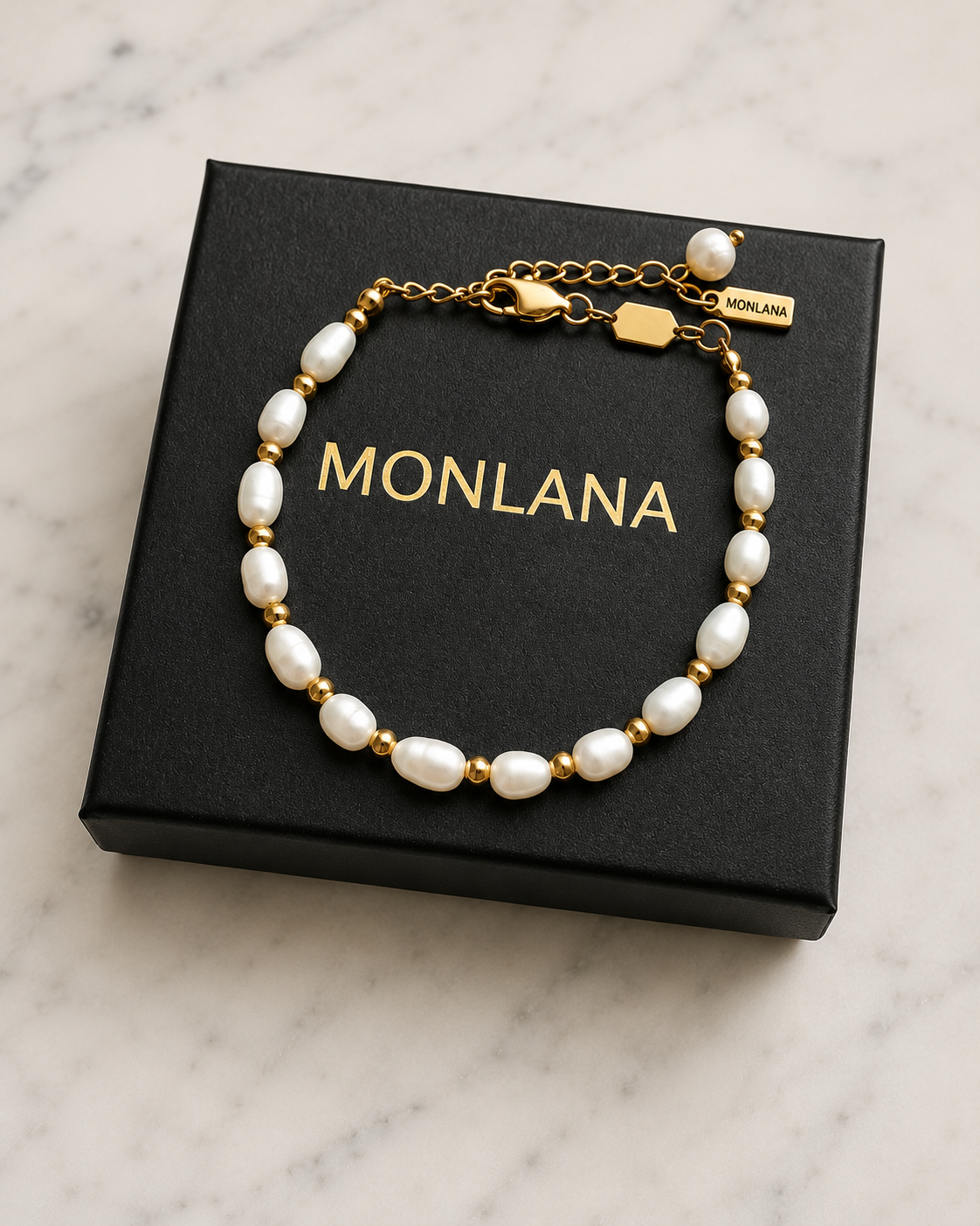 MONLANA natural pearl and gold bracelet displayed on a black gift box