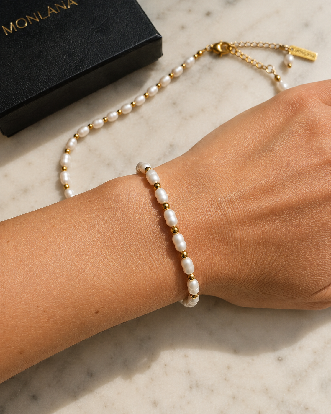 MONLANA natural pearl and gold bracelet worn on a woman's wrist